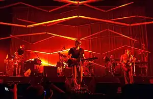 Atoms for Peace performing in 2010. From left to right: Nigel Godrich, Thom Yorke, Flea, and Mauro Refosco (obscured behind Flea, Joey Waronker behind the drums)