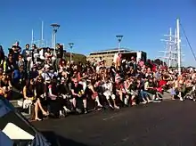 People on steps on a sunny day watching something