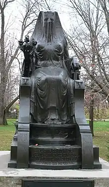 Statue of a woman on a throne covered by a veil