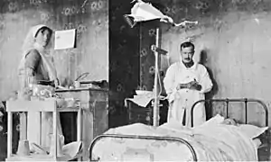 Staff Nurse May Miles and Captain R. V. MacDonnell tend to a patient