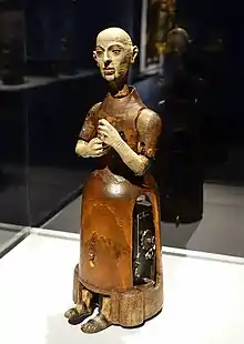 A wooden figure. Gears are visible on the right.