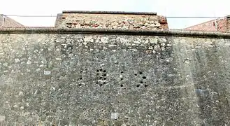Curtain wall with embrasures and date 1812 engraved with the shots fired with cannonballs by Wellington's troops to commemorate the assault on the two bastions.