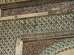 The Arabic inscription running along the top of the gate, with more darj wa ktaf and zellij decoration below