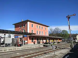 Three-story building with hipped roof next to platform