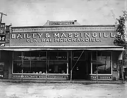 Historic photograph of a single-story store on a city street corner