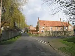 A rural village road with high walls and stone built houses