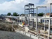 The metal framework of a below-ground railway station under construction