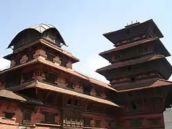 Red-colored multi-storied building and tower like structure.