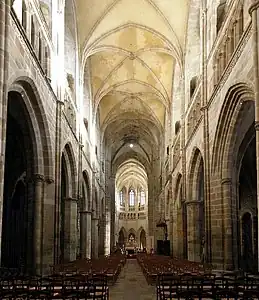 View of the nave. Note typical gothic elevation; grand arcades, triforium and high windows above. Note the vaulted ceiling. The choir can be seen in the distance