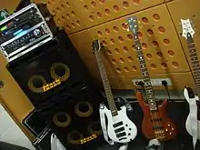 A bass stack has two speaker cabinets (one with four ten-inch loudspeakers and one with two ten-inch loudspeakers). On top of the stacked speaker cabinets is a bass amplifier unit.