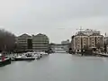 Bassin de la Villette in winter from the central footbridge towards the old warehouses with the old Grands Moulins de Pantin (Great Mills of Pantin) on the right