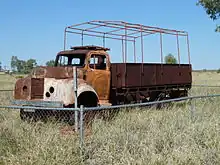 A burnt-out truck, now rusty but still preserved largely intact, 50 years later
