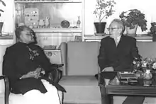 Black and white photograph of Ranasinghe, as first Ceylonese ambassador to Israel, sat in a chair, with Yitzhak Ben-Zvi to his left on a sofa.