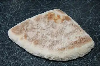 flat, triangular bread with pale surface irregularly covered with browning.