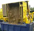 Emptying a suction excavator's spoil hold into a dump truck