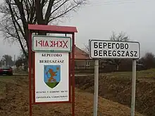 City limit sign, in three scripts, two languages