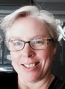 Head shot of Beth Haller, a white woman, with glasses and short white hair