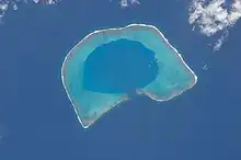 A coral atoll with a mostly enclosed lagoon