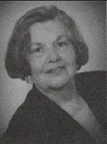 Portrait of a woman with ear-length hair in a dark v-necked top