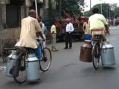 Handles on metal milk churns allow easy carrying