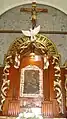 Closeup of the icon in its altar, showing its title and carved frame.