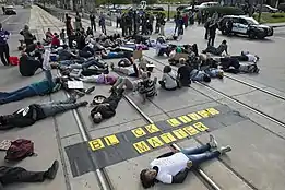 Protesters lying down over rail tracks with a "Black Lives Matter" banner