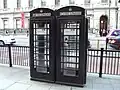Two black K6 telephone boxes in Piccadilly in the City of Westminster, operated by New World Payphones Ltd