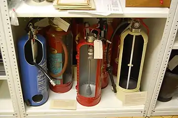 Fire extinguishers in a museum storeroom, cut to display their inner workings