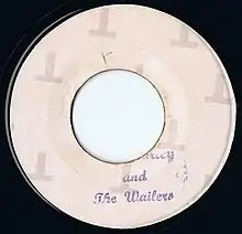 A white vinyl record of the single appears