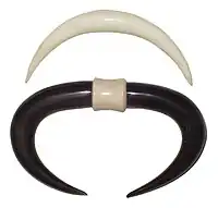 Hand carved tusks made out of horn, normally worn in nasal septum piercings
