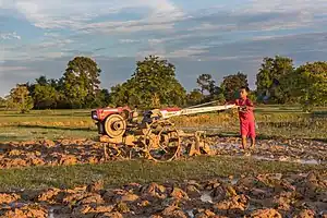 Boy plowing with a tractor at sunset in Don Det, Laos.