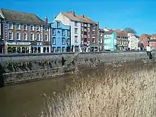 Three and four-storey buildings on the far side of a river.
