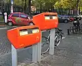 A Dutch "Post-NL" postbox in orange at different heights