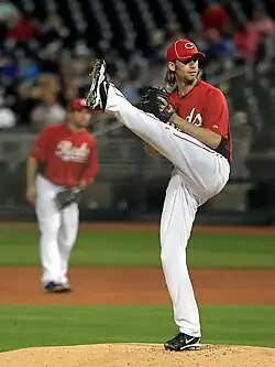 A man in white baseball pants and red jersey and cap