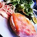 Some brunch foods – a bagel with cream cheese topped with smoked salmon, and salad