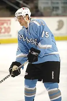 Hockey player standing on the ice in a powder blue uniform