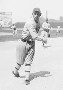 A black and white photograph of a baseball player posed as if having just thrown a ball