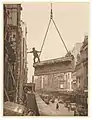 Building labourer on a stone being hoisted up to building, Pitt St, Sydney, c1930s. Photo by Sam Hood.