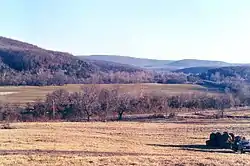 Picture of Bunch almost hidden in the trees from about 1 mile north.  There is a Kansas City Southern freight-train just across the road