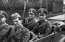 SD men in Poland 1939. The SD men are wearing army shoulder straps, akin to the Waffen-SS, except for the Rottenführer in the front seat, who is wearing the older shoulder straps of the Allgemeine SS.