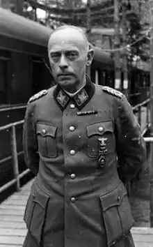 A man in semi profile wearing a military uniform and various military decorations. He has short, thinning hair.
