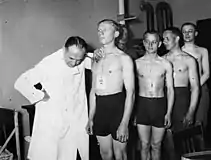 Men standing in line waiting for a medical check