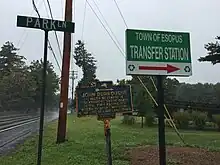 a picture of the marker, next to a sign pointing, like this historic marker does, to the town's transfer station