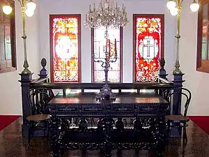 Furniture on the second floor landing, showing the stained-glass windows above the staircase