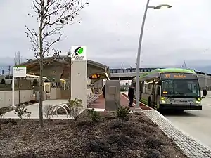 A bus at a bus station with a curved canopy