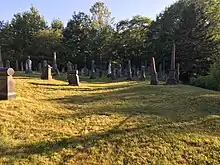 Grave stones in a grassy field.