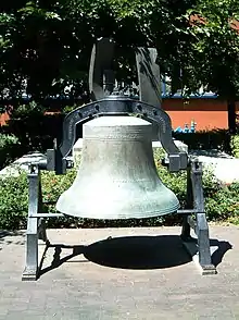 A picture of a large, rusted bell, positioned outside San Jose State University.