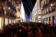 A crowded street with decorative lights.