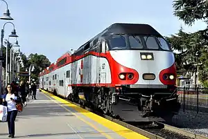 A red and white locomotive at a train station