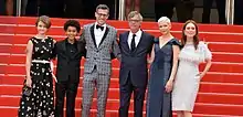 Jaden Michael (2nd from left), wearing a black tuxedo on the red carpet of Cannes 2017